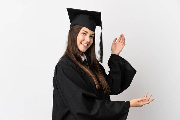 Teenager Brazilian university graduate over isolated white background extending hands to the side for inviting to come - Foto, Imagen