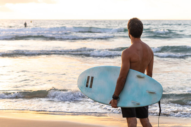 Young caucasian man get up early to  doing surf at sunrise - Фото, изображение
