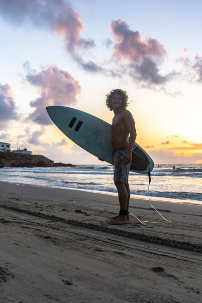 Giovane uomo caucasico alzarsi presto per fare surf all'alba - Foto, immagini