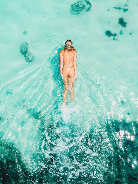 Young naked woman snorkeling in turquoise ocean. Aerial view, top view - Zdjęcie, obraz