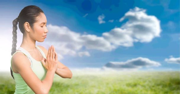 Composition of fit woman meditating over blue sky and clouds. sport, fitness and active lifestyle concept digitally generated image. - Foto, Bild