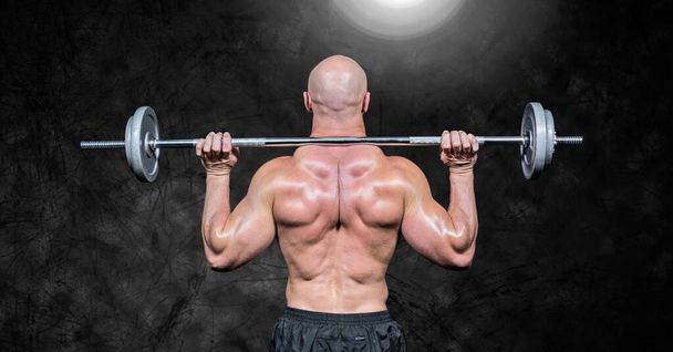 Composition of rear view of muscular man lifting weights with glowing light on black background. sport, fitness and active lifestyle concept digitally generated image. - Valokuva, kuva