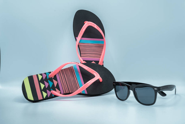 Sommersonnenbrille und Flip-Flops mit Kopierraum und blauem Hintergrund - Foto, Bild