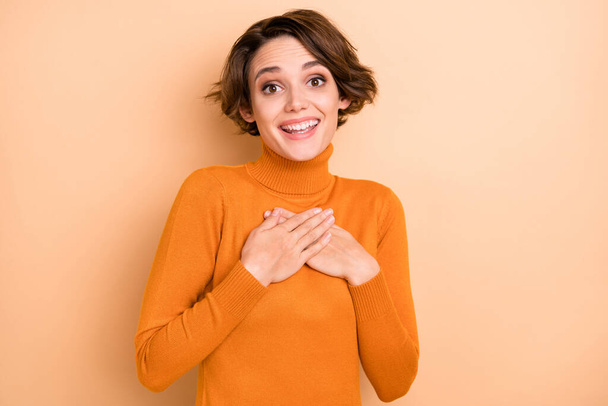 Photo of young lovelt attractive pretty happy positive smiling girl hold hands on chest isolated on beige color background - 写真・画像