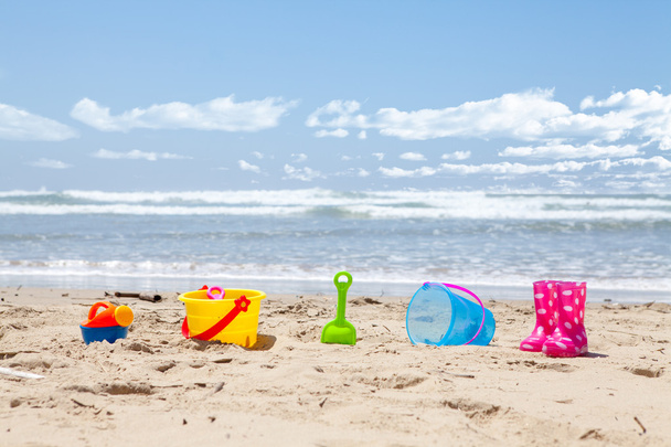 Brightly colored plastic beach toys on the beach - Photo, Image