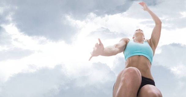 Composition of athletic woman jumping over sky with clouds. sport, fitness and active lifestyle concept digitally generated image. - Photo, Image