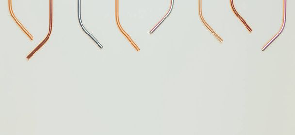 Multicolored reusable stainless steel straws on light gray background. Top view, copy space - Photo, Image
