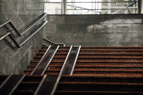 Серые лестницы с пандусом для инвалидов. Городская архитектура. Выход из метро или подземного перехода. - Фото, изображение