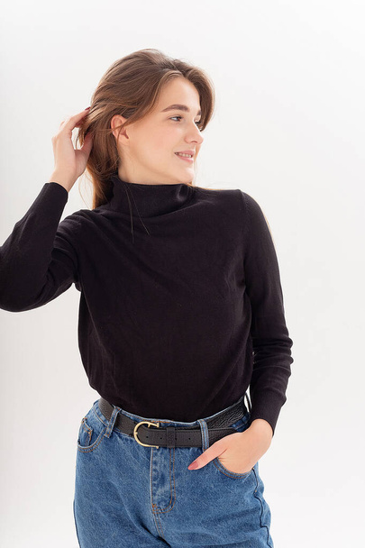 young attractive caucasian woman with long hair in black turtleneck, blue jeans - Фото, зображення