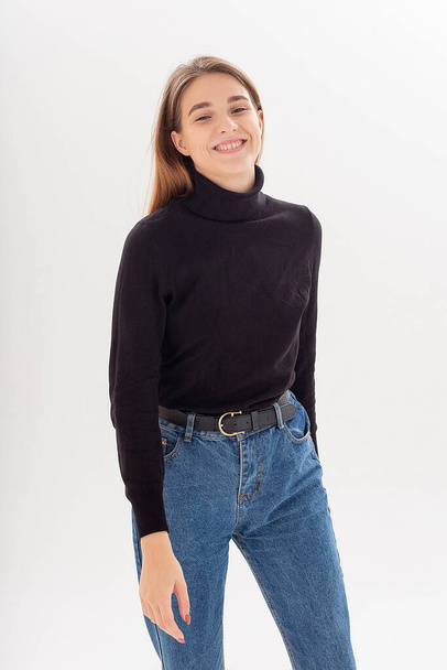 young attractive caucasian woman with long hair in black turtleneck, blue jeans - Foto, Imagen
