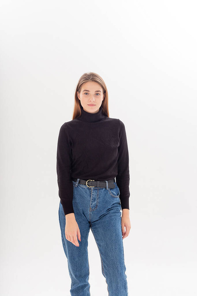 young attractive caucasian woman with long hair in black turtleneck, blue jeans - Фото, зображення