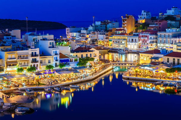 Aghiosニコラオスの夜景-島の東に絵のような町クレタ島ミラベッロの平和的な湾の北西側に建てられました - 写真・画像