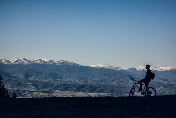 σιλουέτα του ανθρώπου ιππασία ποδήλατο σε φόντο βουνά  - Φωτογραφία, εικόνα