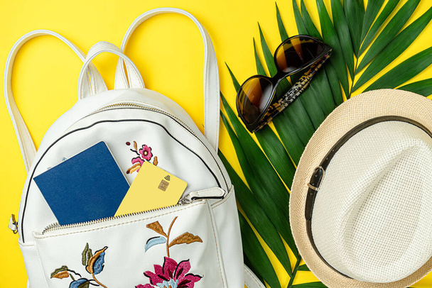 Concept de voyage d'été. Accessoires, sac à dos avec passeport et carte de crédit sur fond jaune vif. - Photo, image