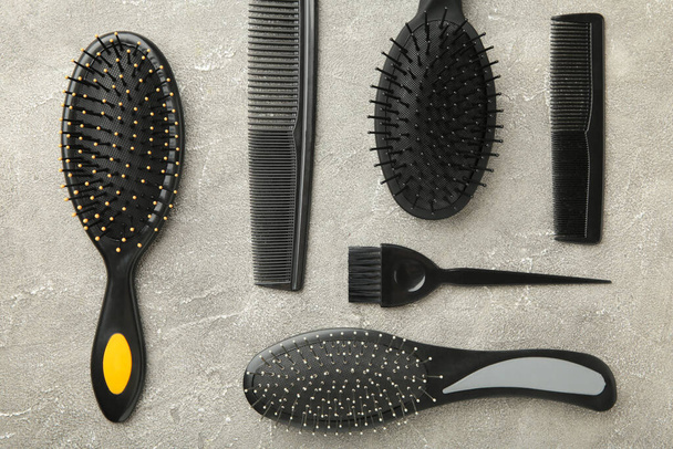 Hair tools, beauty and hairdressing concept - different brushes or combs on grey background. Top view - Foto, imagen