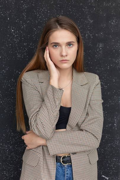 young attractive caucasian woman with long hair in black top and suit jacket - 写真・画像