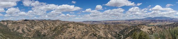 Los Padres National Forest, CA, USA - 21 травня 2021: Wide panorama знімали східну частину під важким блакитним хмарним пейзажем з дорогою 33, що пробивається крізь неї. Зелені дерева і чагарники. - Фото, зображення