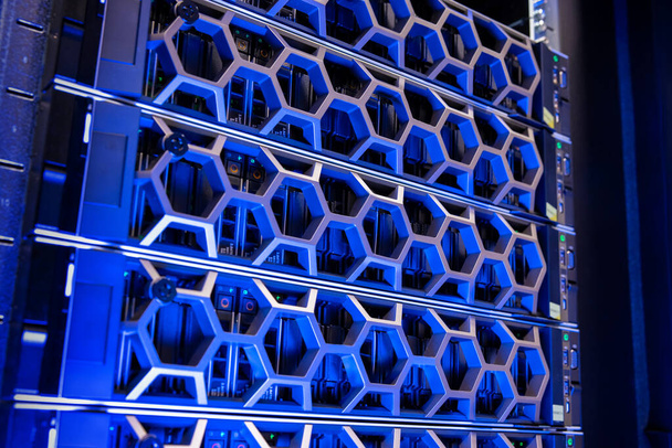 Gros plan des disques durs modernes dans le centre de données virtuel bleu éclairé - Photo, image