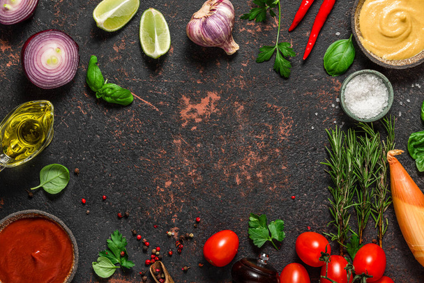 Cooking food composition. Frame made of fresh vegetables, spices, herbs and sauces on black stone background. Top view with copy space. Keto diet. Flat lay - Fotografie, Obrázek