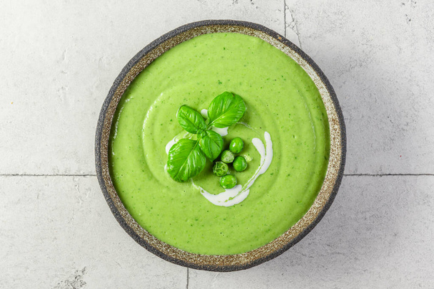 Summer cream soup with green pea, broccoli and basil. Healthy vegetarian food. top view - Foto, Bild