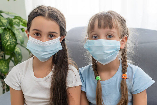 滅菌顔のマスクの2人の子供の女の子。疫学的パンデミックコロナウイルス2019-nconv sars covid-19インフルエンザウイルスの概念. - 写真・画像