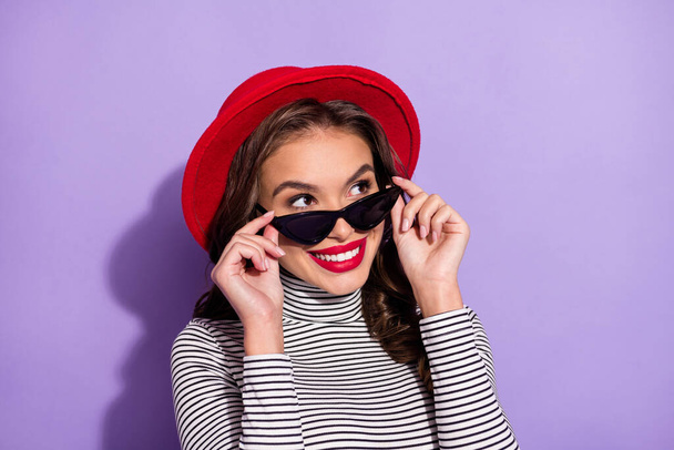Photo of young cheerful girl happy positive smile hands touch sunglass look empty space isolated over violet color background - Foto, Imagem