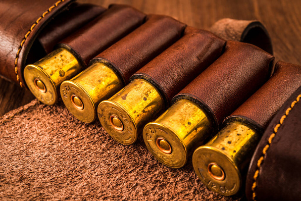 Hunting ammunition 12 gauge in leather bandolier on a wooden tab - Fotó, kép