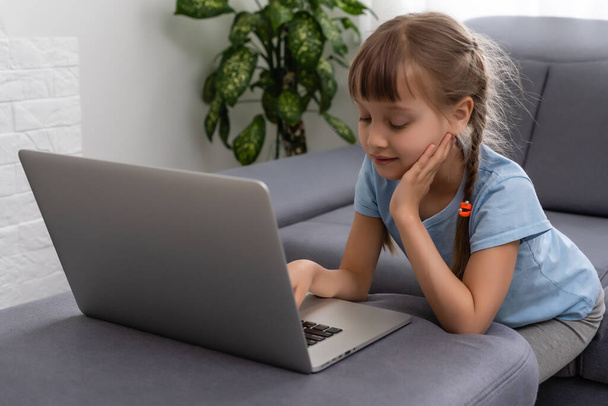 niña estudiando con el ordenador, niña con el ordenador portátil en línea. - Foto, imagen