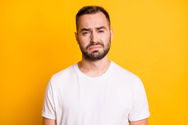 Portrait of attractive miserable capricious bearded guy feeling bad isolated over bright yellow color background - Foto, afbeelding