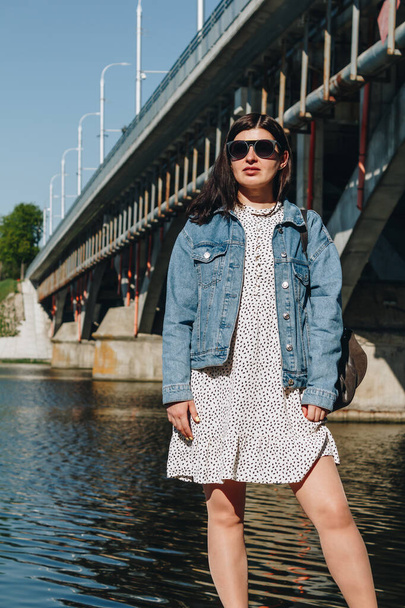 Portrait of brunette woman in sunglasses and jean jacket - Photo, Image