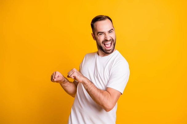 Portrait of optimistic funky guy dance wear grey t-shirt isolated on yellow color background - Fotografie, Obrázek