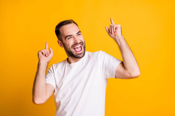 Portrait of attractive cheerful guy dancing having fun rest isolated over bright yellow color background - Фото, изображение
