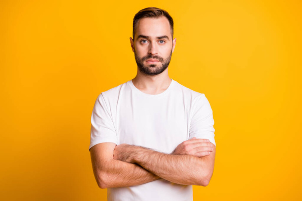 Portrait of nice serious bearded guy gym trainer folded arms isolated over bright yellow color background - Foto, afbeelding