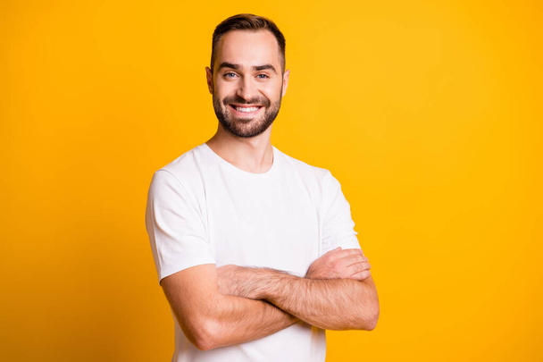 Portrait of attractive cheerful sportive bearded guy gym trainer folded arms isolated over bright yellow color background - Фото, изображение