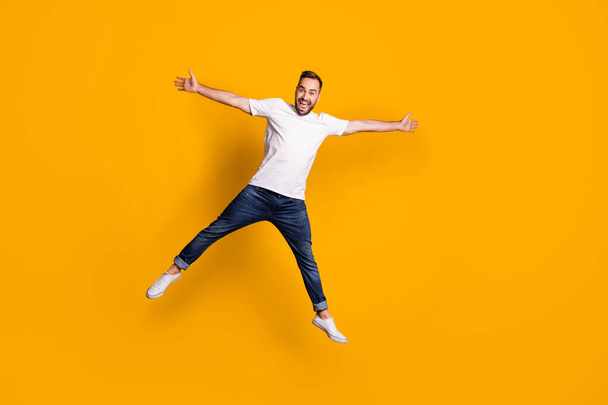 Full length body size view of nice childish cheerful guy jumping having fun fooling isolated over bright yellow color background - Fotó, kép