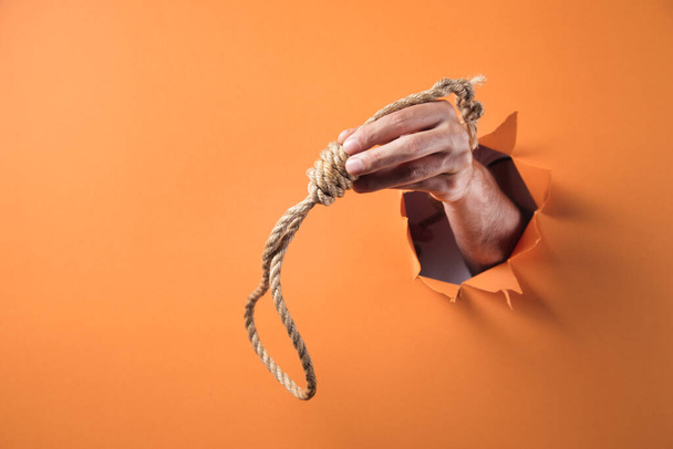 Hand holds choke loop on orange background - Foto, immagini