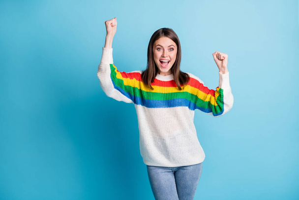 Portrait of nice hooray brunette lady hands fists wear colorful sweater isolated on blue color background - Фото, зображення
