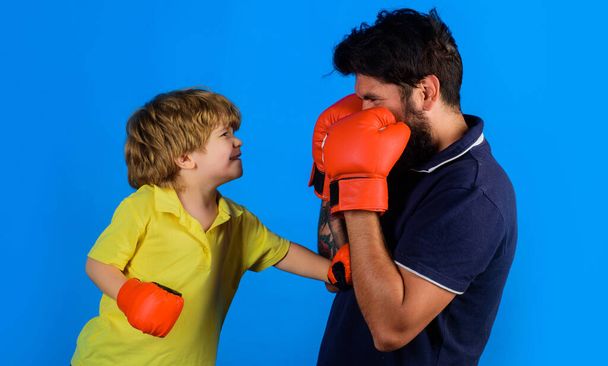 Father and son during boxing training. Dad and child with boxing gloves. Childhood activity. Working out together. - Photo, Image