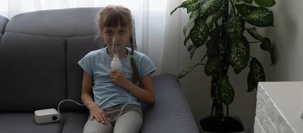 Маленькая девочка делает вдох с распылителем дома. детская астма ингалятор ингалятора ингаляции туманность пара больных кашлем концепция. - Фото, изображение