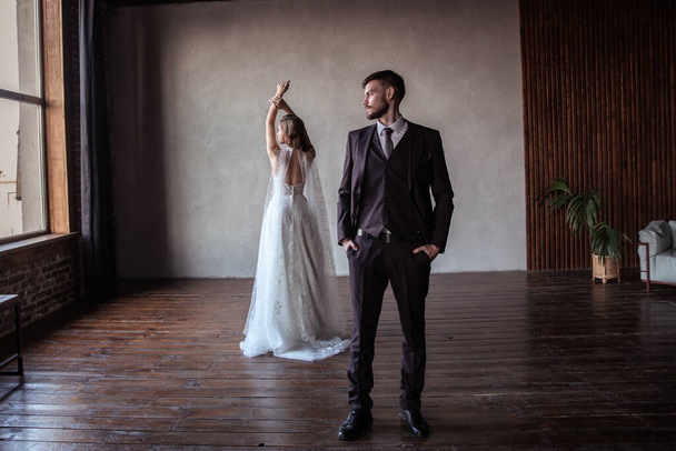 beautiful young couple. groom and bride. a modern wedding. dark interior. - Fotó, kép
