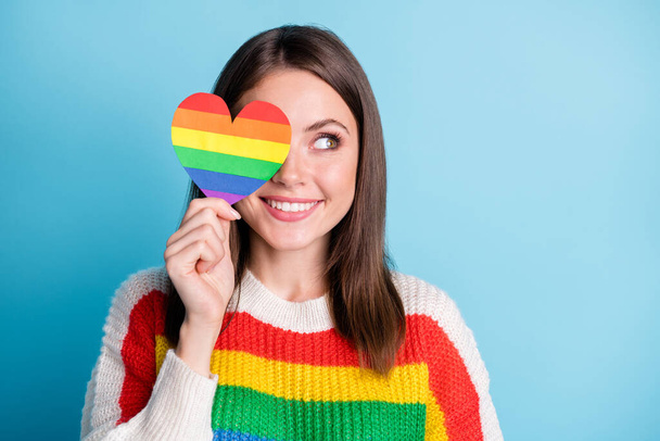 Photo of optimistic brunette lady look empty space show rainbow heart wear sweater isolated on blue color background - Valokuva, kuva
