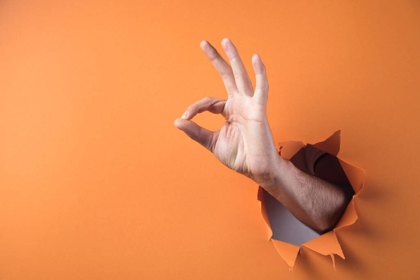 Hand shows ok on orange background - Foto, Imagem
