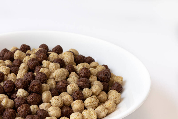 chocolate vanilla cereal in bowl isolated on white background, chocolate brown and white balls, healthy breakfast - Foto, Imagem