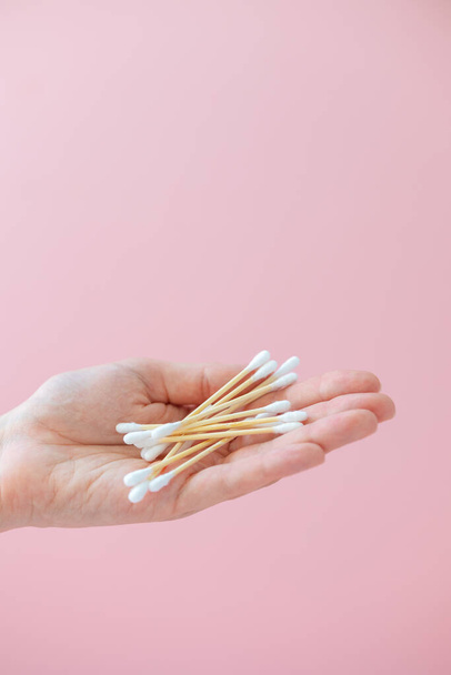 environmentally friendly bamboo and cotton cotton buds on a pink background, bamboo toothbrushes for adults and children. human personal hygiene products without harming the environment - Fotografie, Obrázek