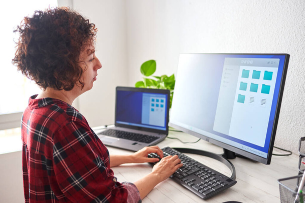 Mujer escribiendo en un teclado de ordenador a la luz del día natural - Foto, imagen