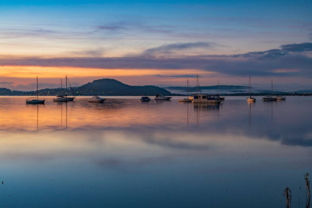 A soft pretty sunrise with boats and fog at Koolewong Waterfront on the Central Coast, NSW, Australia. - Valokuva, kuva