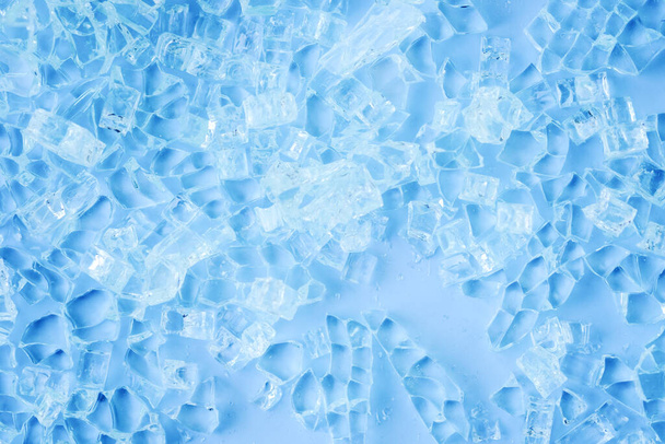 Photo de morceaux de verre cassés sur fond bleu. Concept minimaliste abstrait. Espace pour le texte  - Photo, image