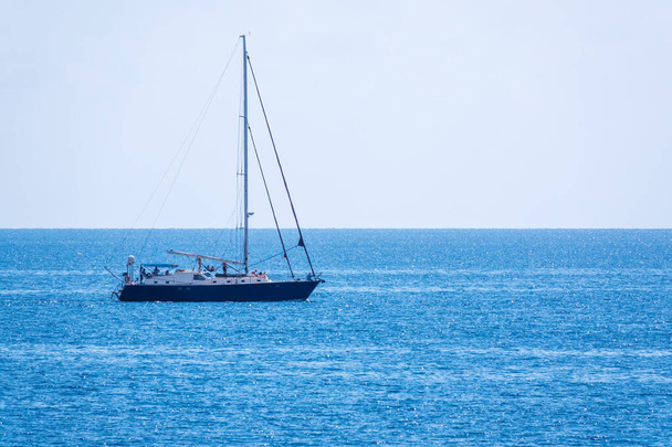 Sailing yacht in the blue calm sea. A yacht in peaceful waters. - Foto, immagini