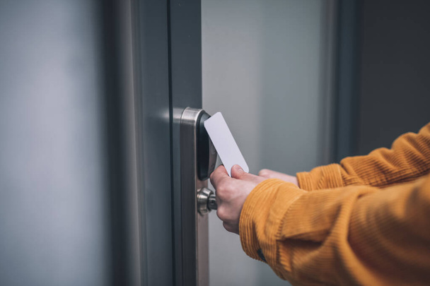 Close up of mans hand opening the door with an access card - Valokuva, kuva