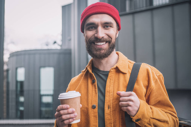 Young man in a red hat smiling positively - Фото, изображение
